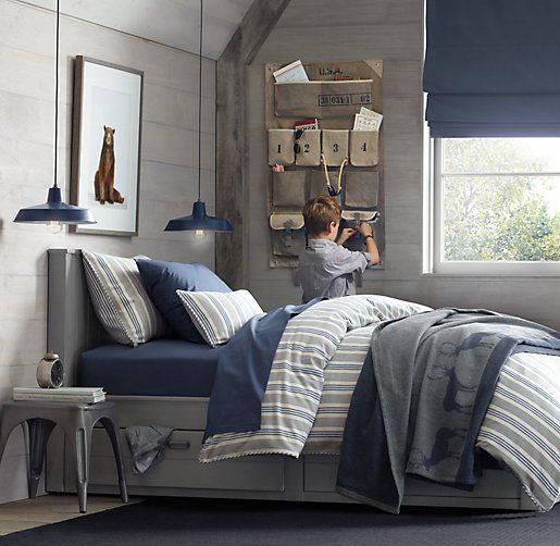 This is a perfect bedroom to plan for your attic purposes. Instead of highlighting the navy blue with white, use grey. The room looks less simple but gives convenience. The bed frame in itself is large but the headboard is not that huge. This gives you plenty of space to hang something behind the bed. Navy blue lamps give convenience for reading at night. The blinds don’t look as elegant as curtains but a good choice to make the bedroom more convenient. The overall wood use adds warmth to the entire view.